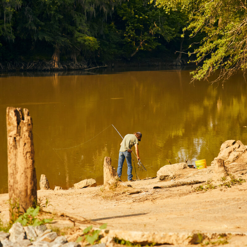 Man fishes off the bank of the Oconee River