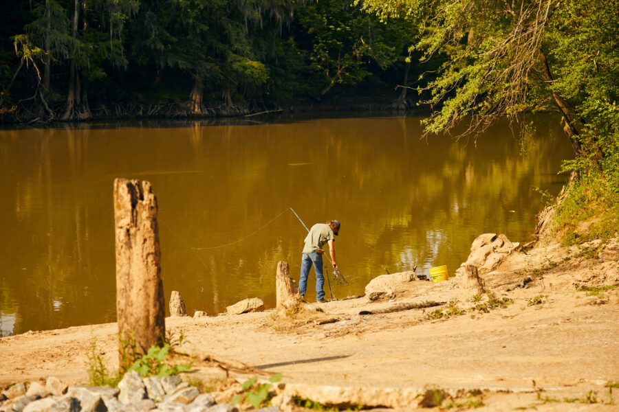 Man fishes off the bank of the Oconee River
