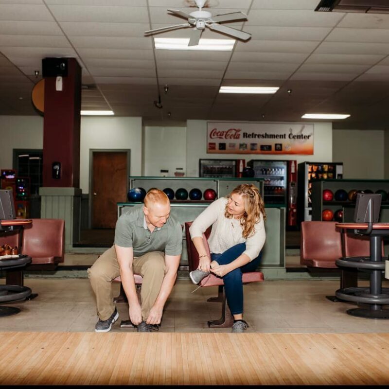Man and woman lacing up their bowling shoes at Shamrock Bowling Center.