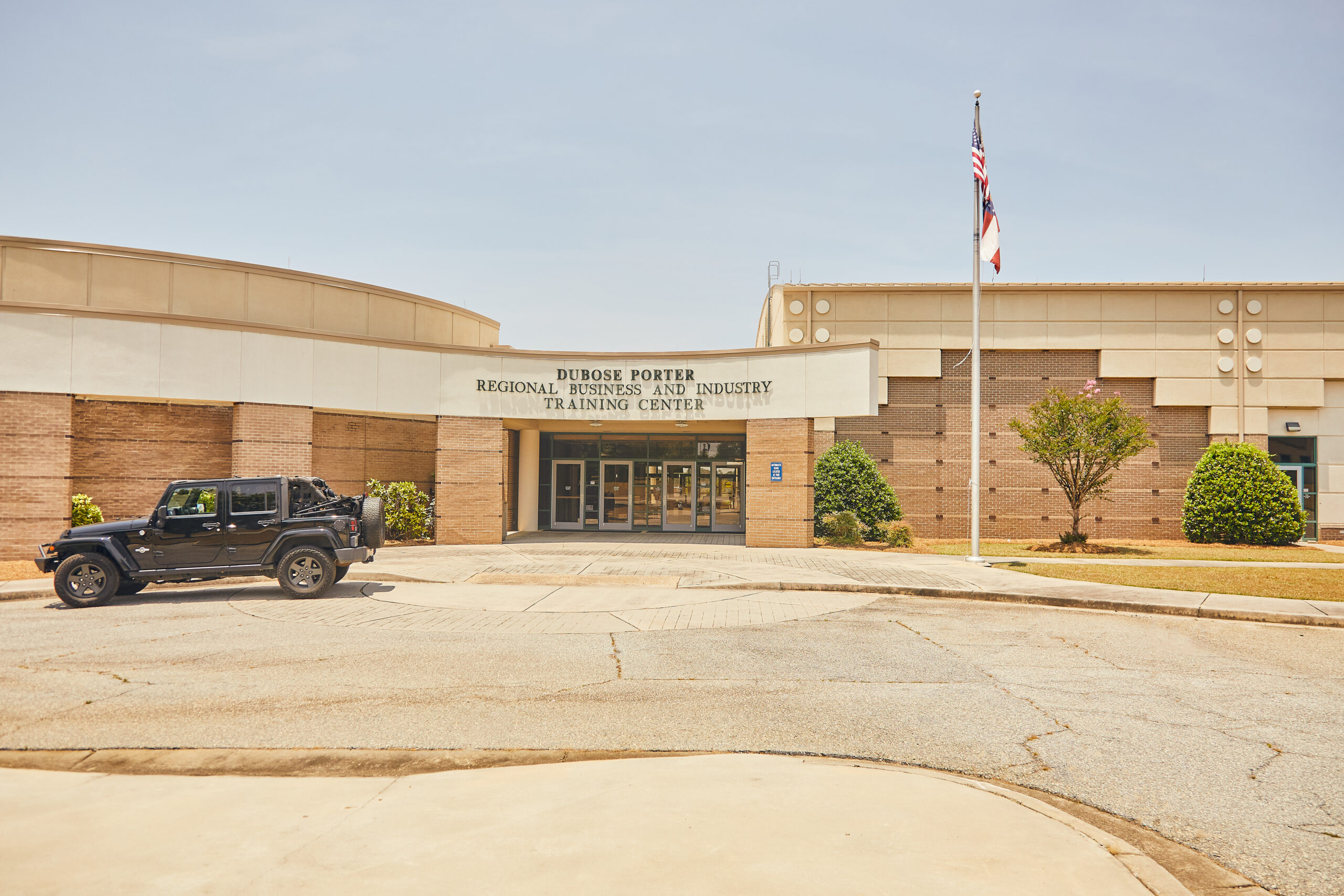 exterior view of OFTC Conference Center, with a black jeep parked in front