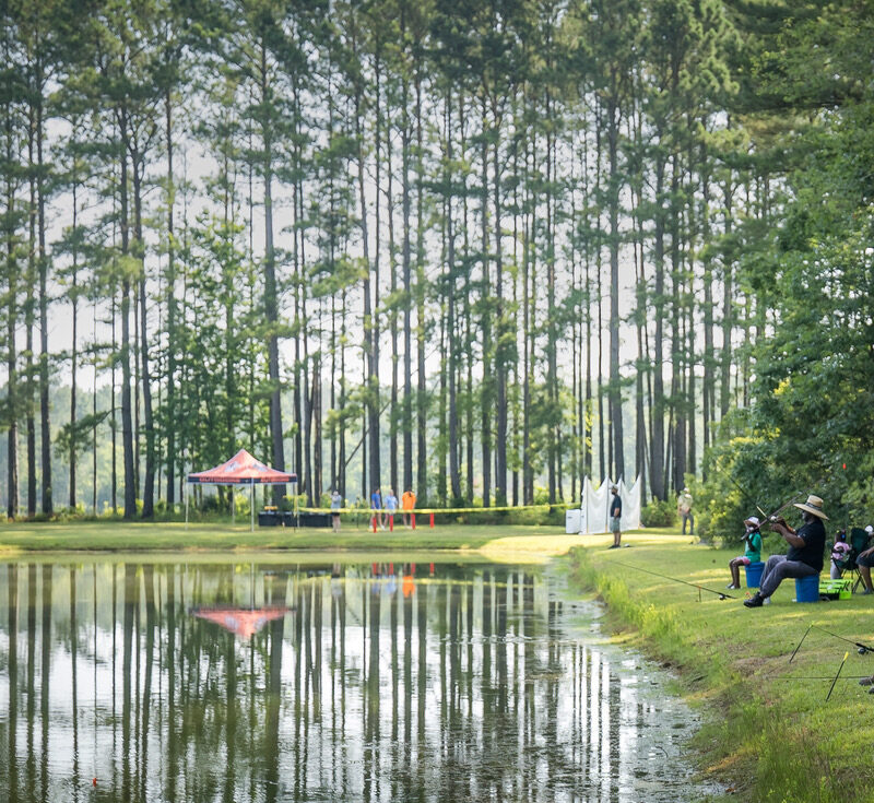 People fishing surrounded by pine trees at Hugh Gillis PFA.