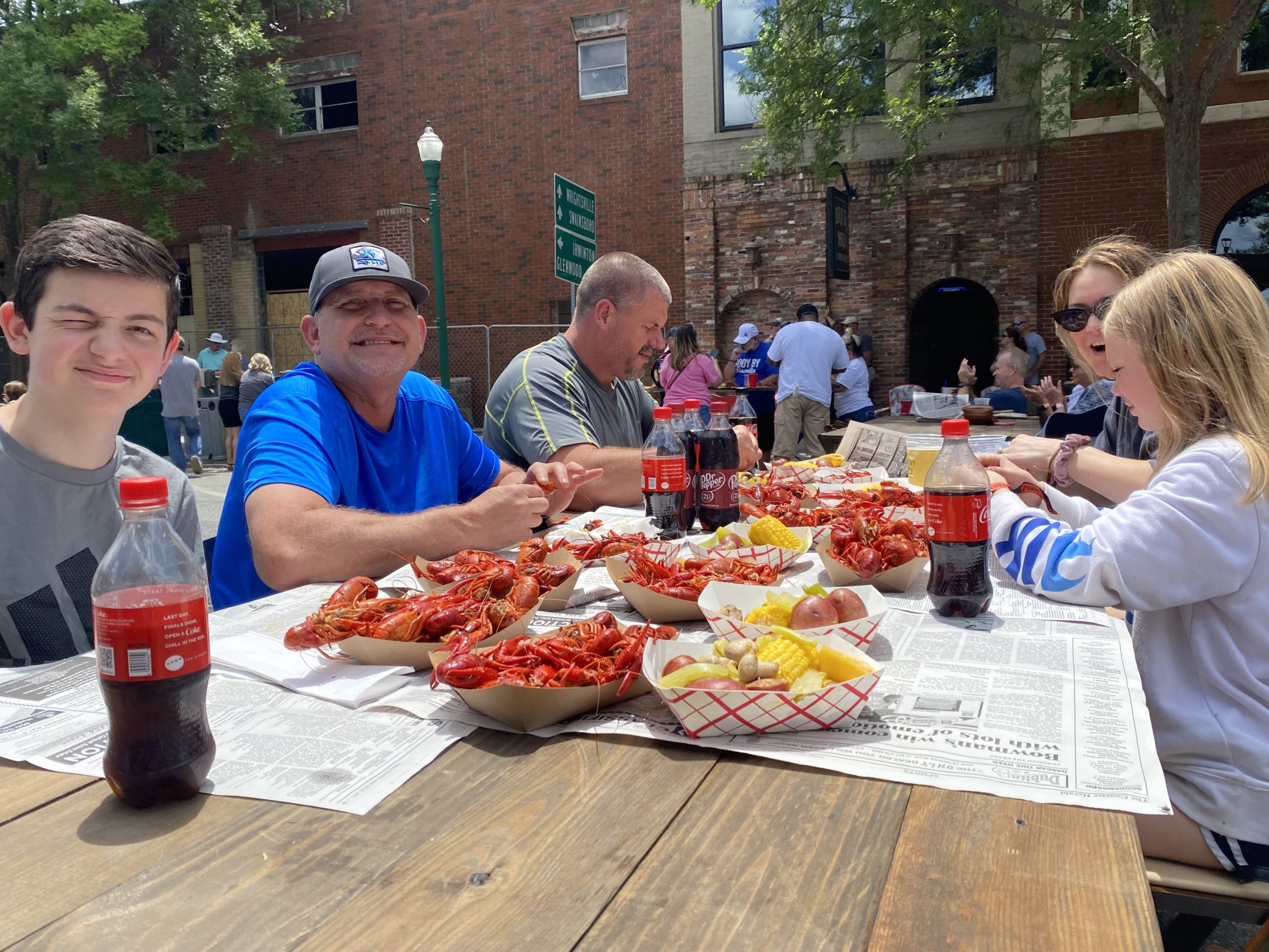 Family enjoys crawfish at picnic table in May