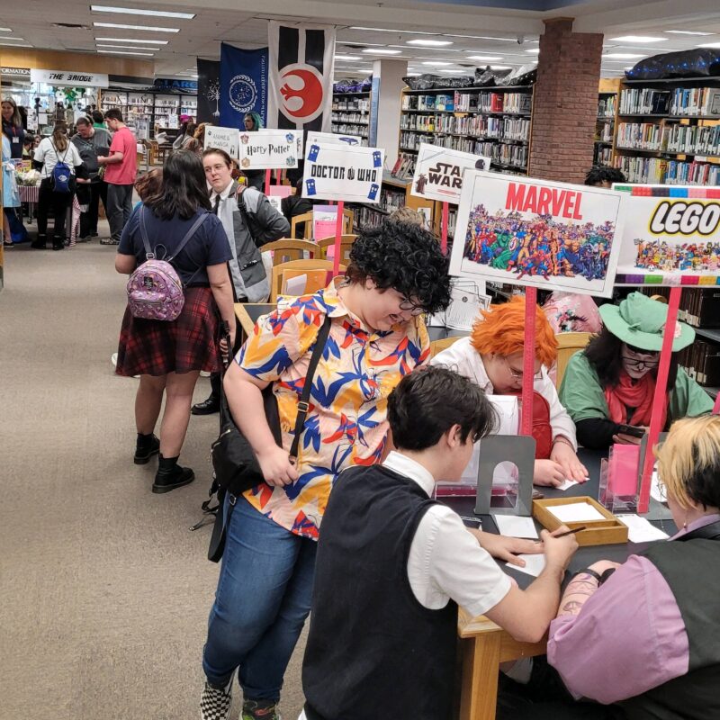 Cosplayers take part in activity tables lining the bookshelves at the Laurens County Library during Fantastic Futures: Dublin FanCon.
