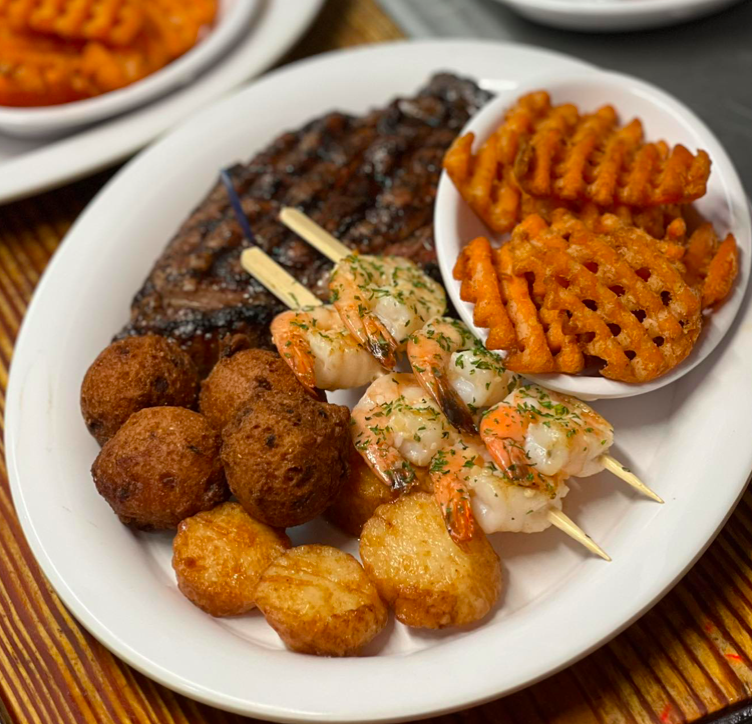 A full plate of steak, shrimp on a stick, sweet potato fries, and more at Tumpie House