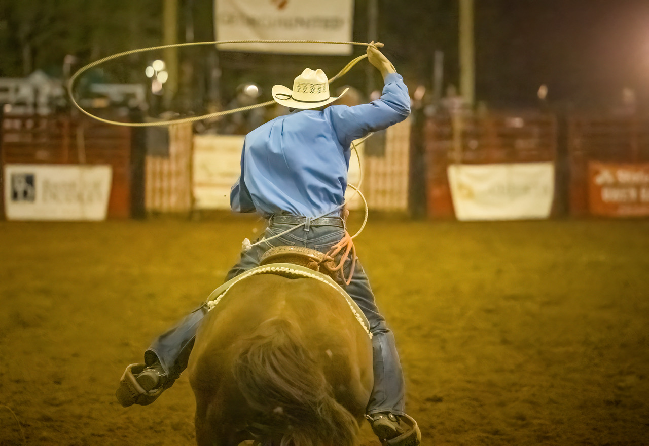 Cowboy rides on his horse prepping his lasso for the Easterseals Pro Rodeo