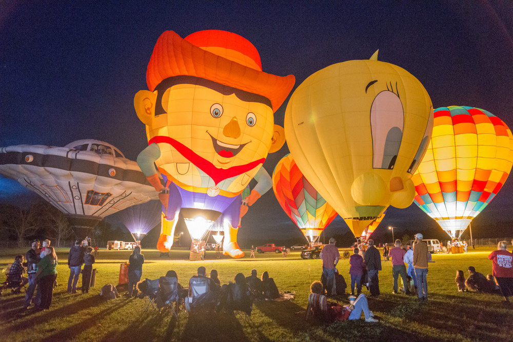 People watch as balloons are aglow athe the Irish Balloon Festival and Glow