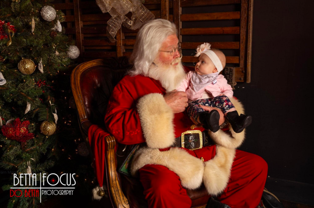 Santa holds small baby - Santa's Coming to Town