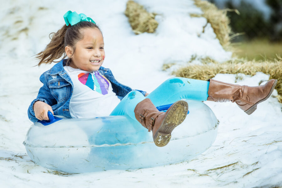girl on tube going down snow slide