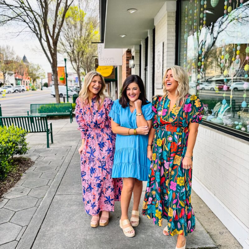 Three ladies standing on the sidewalk in Downtown Dublin modeling colorful Mint Boutique dresses.