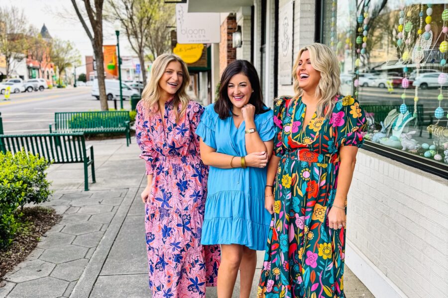 Three ladies standing on the sidewalk in Downtown Dublin modeling colorful Mint Boutique dresses.
