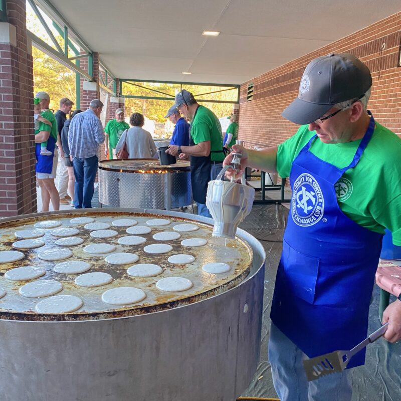 Pancakes being cooked on a giant griddle during the St. Patrick's Pancake Supper.