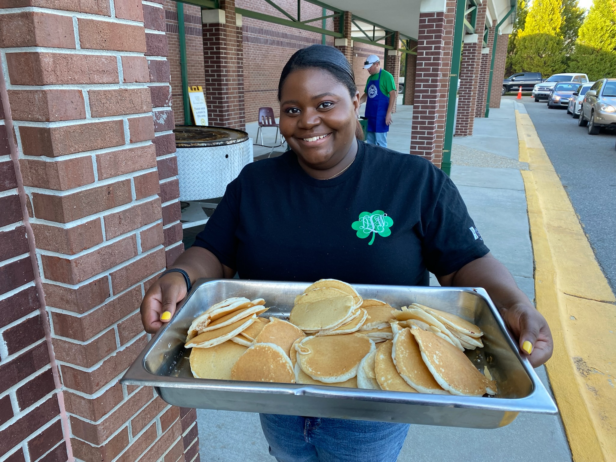 A volunteer with a large pan of pancakes during the St. Patrick's Pancake Supper.