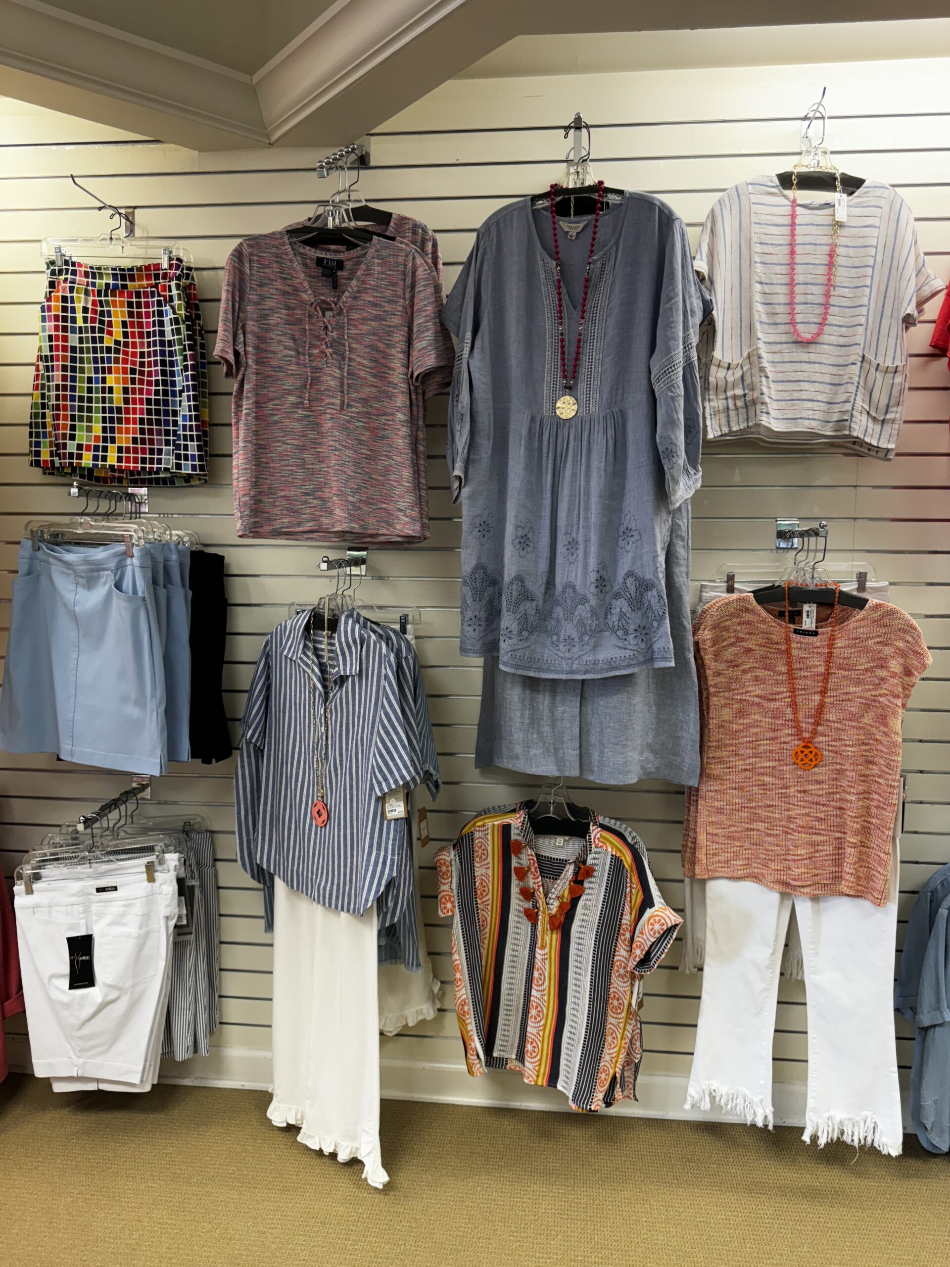 A wall lined with assorted clothing pieces at Plum Alley