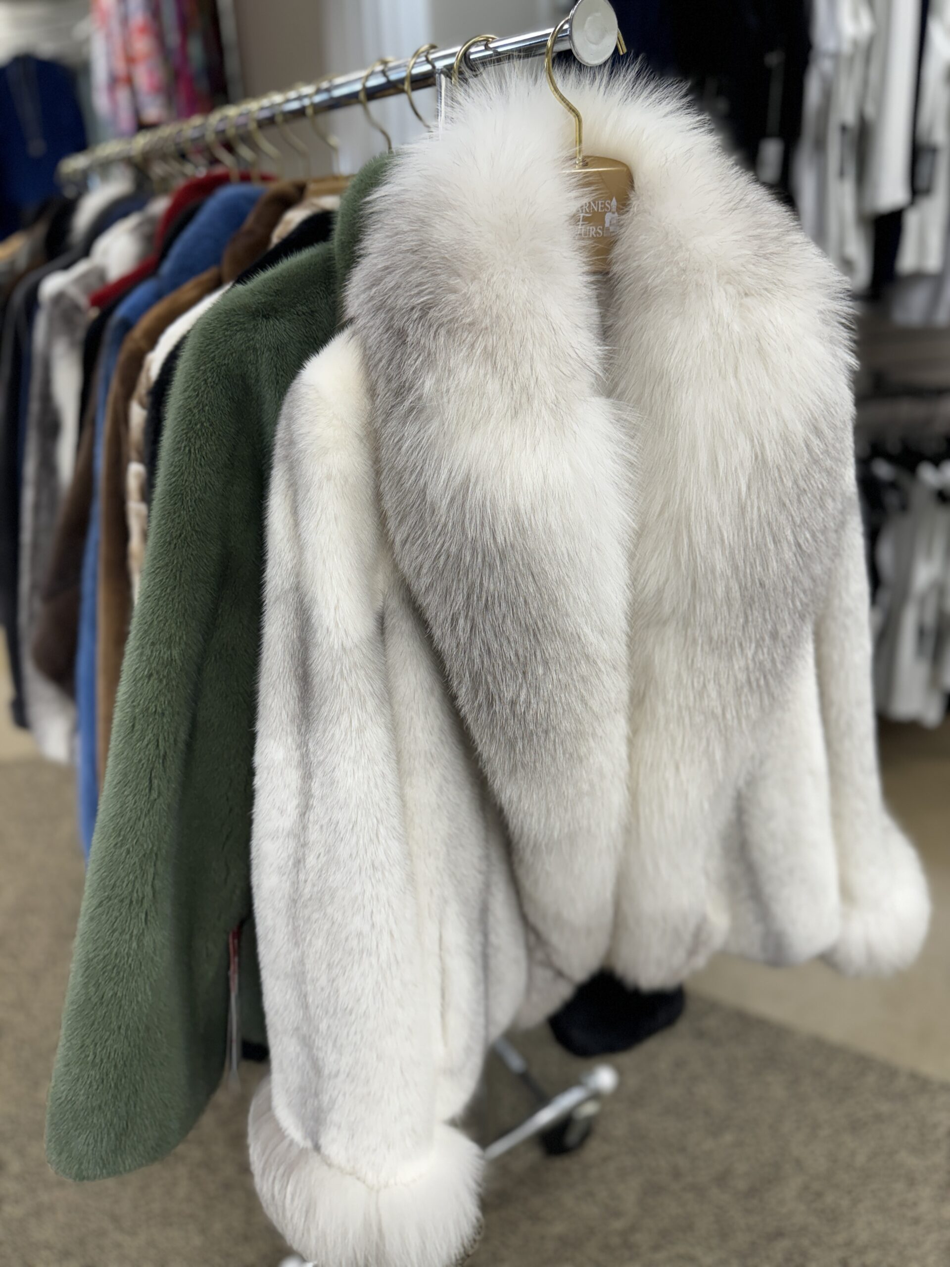 A rack of fur coats in a variety of colors