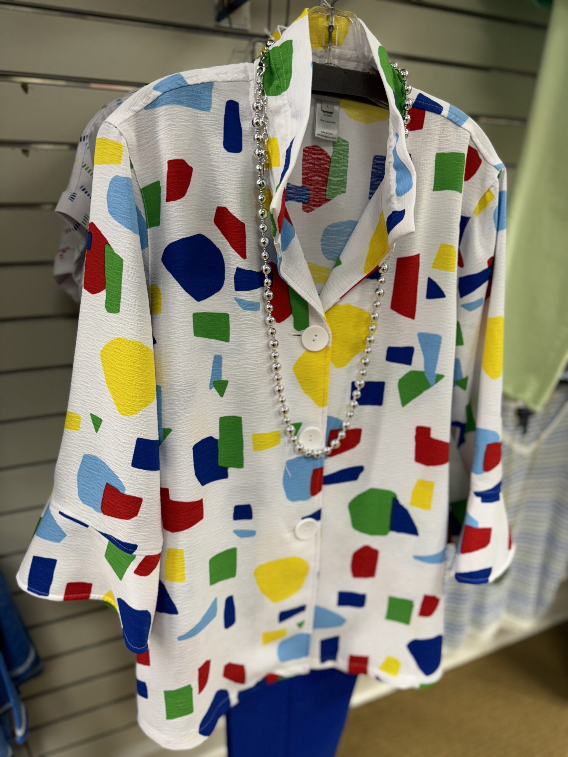 A white blouse with multicolored geometric shapes