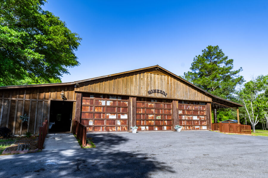 Outside view of Rinesdi Acres rustic event space on a sunny day with the bright blue sky as a backdrop.