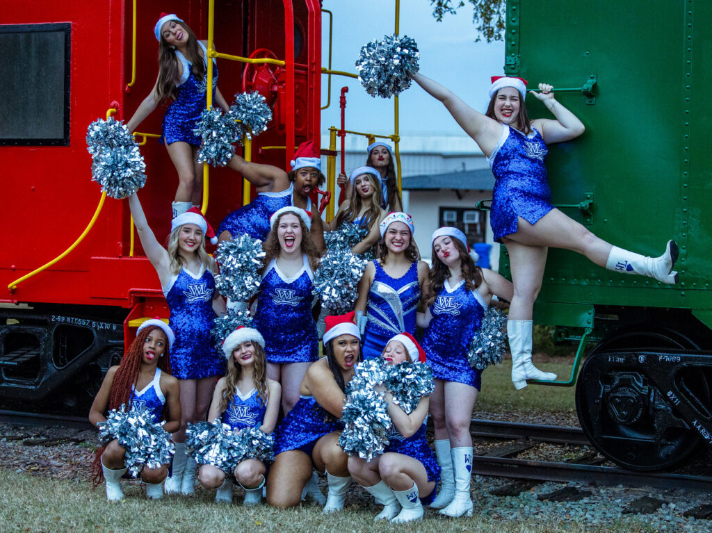 Cheerleaders in Santa hats posing on a caboose and train car in Downtown Dulblin, a few blocks from Theatre Dublin where the movie Polar Express is watched each holiday season.