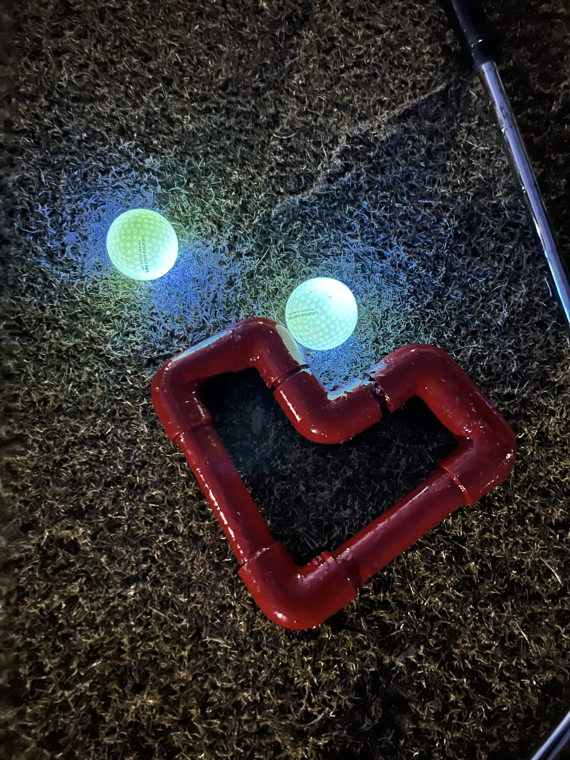 Heart shaped markers and glow in the dark balls on putting green for Hearts & Clubs event.