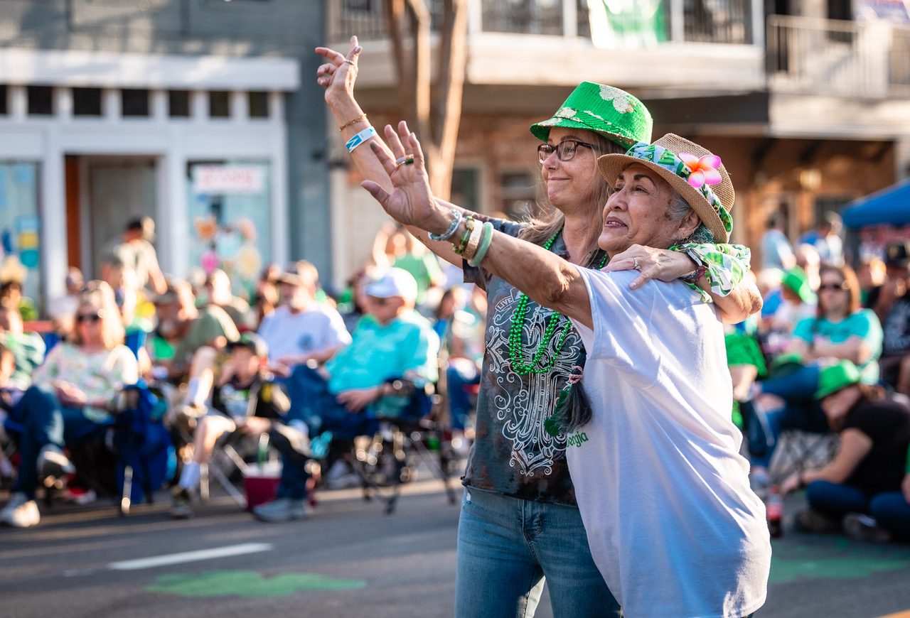 Two women excitedly wave at the band playing at Music and Munchies