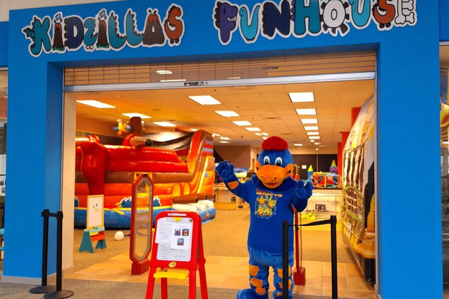 The Kidzilla Funhouse mascot standing in the doorway of the location.
