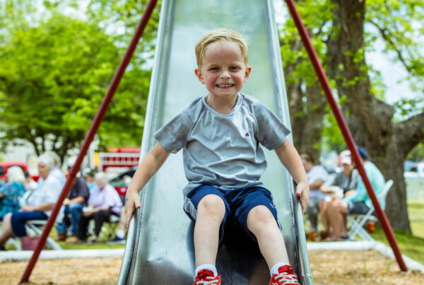 Kid playing on a slide at a park. one of the activities in the Dublin, GA summer guide.