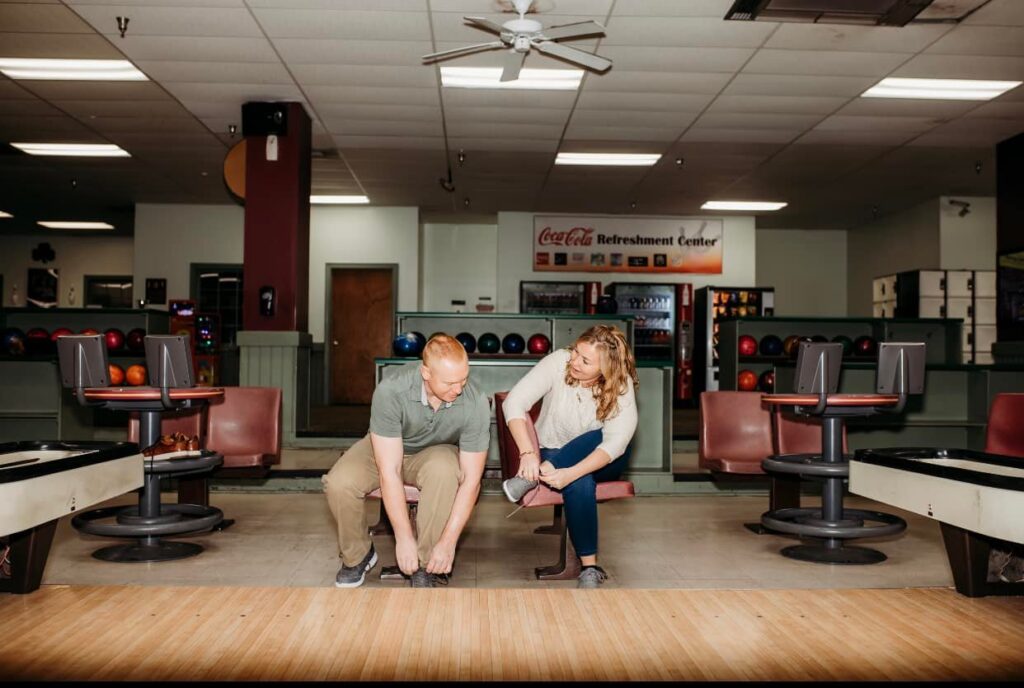 Man and woman lacing up their bowling shoes at Shamrock Bowling Center.
