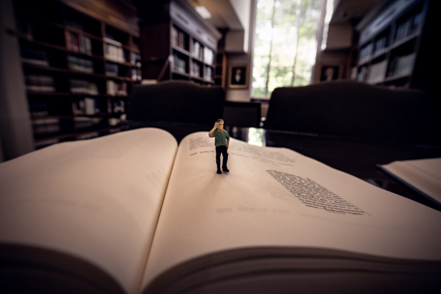 Tiny miniature caricature standing on the open pages of a book at the Laurens County Library. The photo was captured during a Fall Used book Sale.