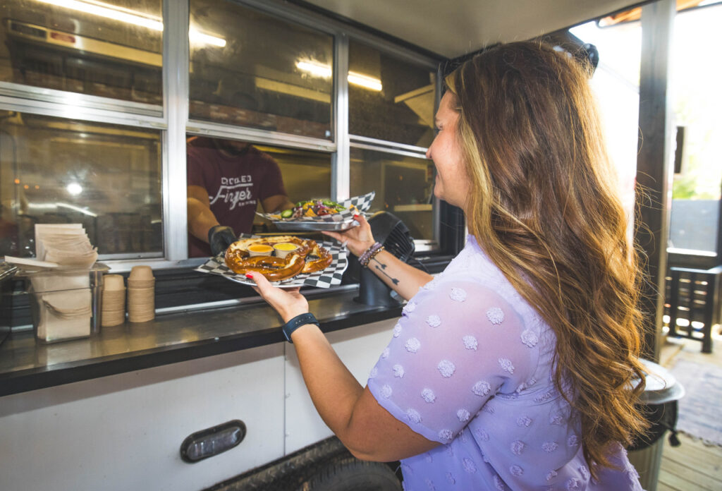 Woman getting food from the food truck last Crooked Finger Brewing, while eating in downtown Dublin.