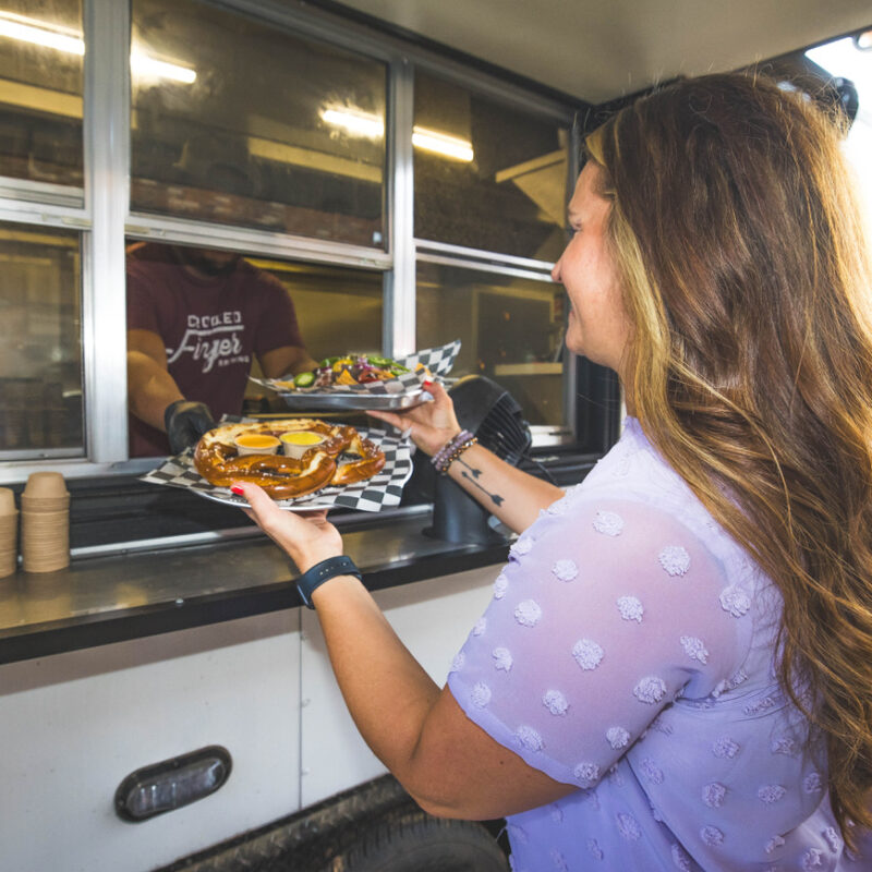 Woman getting food from the food truck last Crooked Finger Brewing, while eating in downtown Dublin.