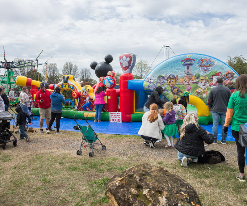 Families gathered around a kid's bouncy house during the St. Patrick's Festival. Tourism grant funding provides marketing support for the festival.