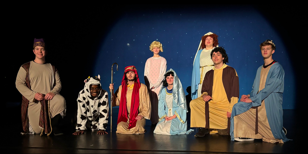 The cast of A Charlie Brown Christmas LIVE stand in a nativity scene - Dublin Community Theatre