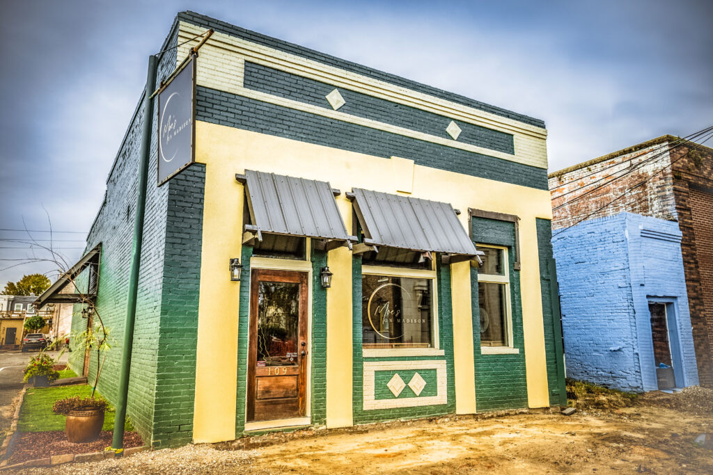 Exterior view of green and beige Moe's On Madison.