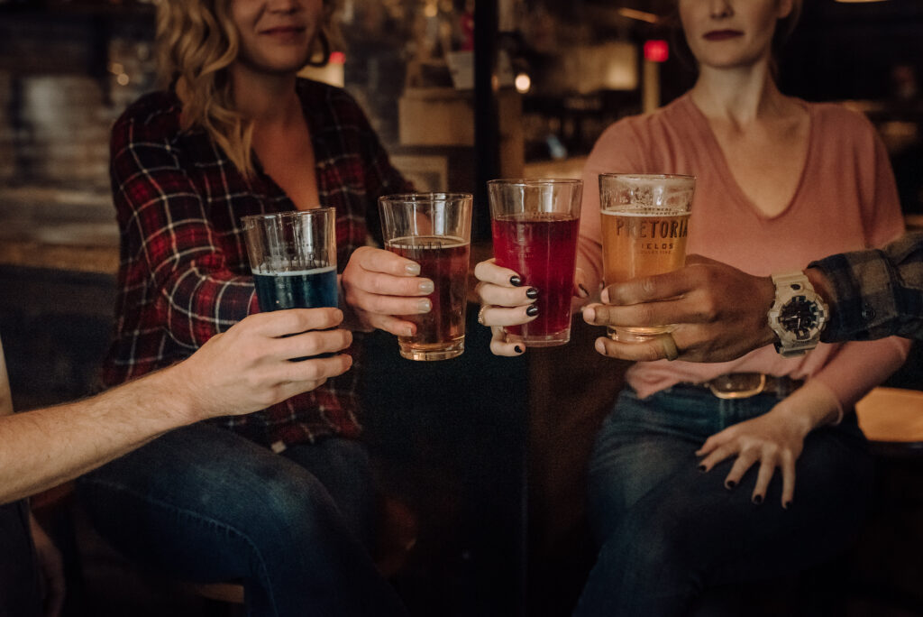 Friends sharing a cheers with several craft brews at Company Supply, which is open on Monday.