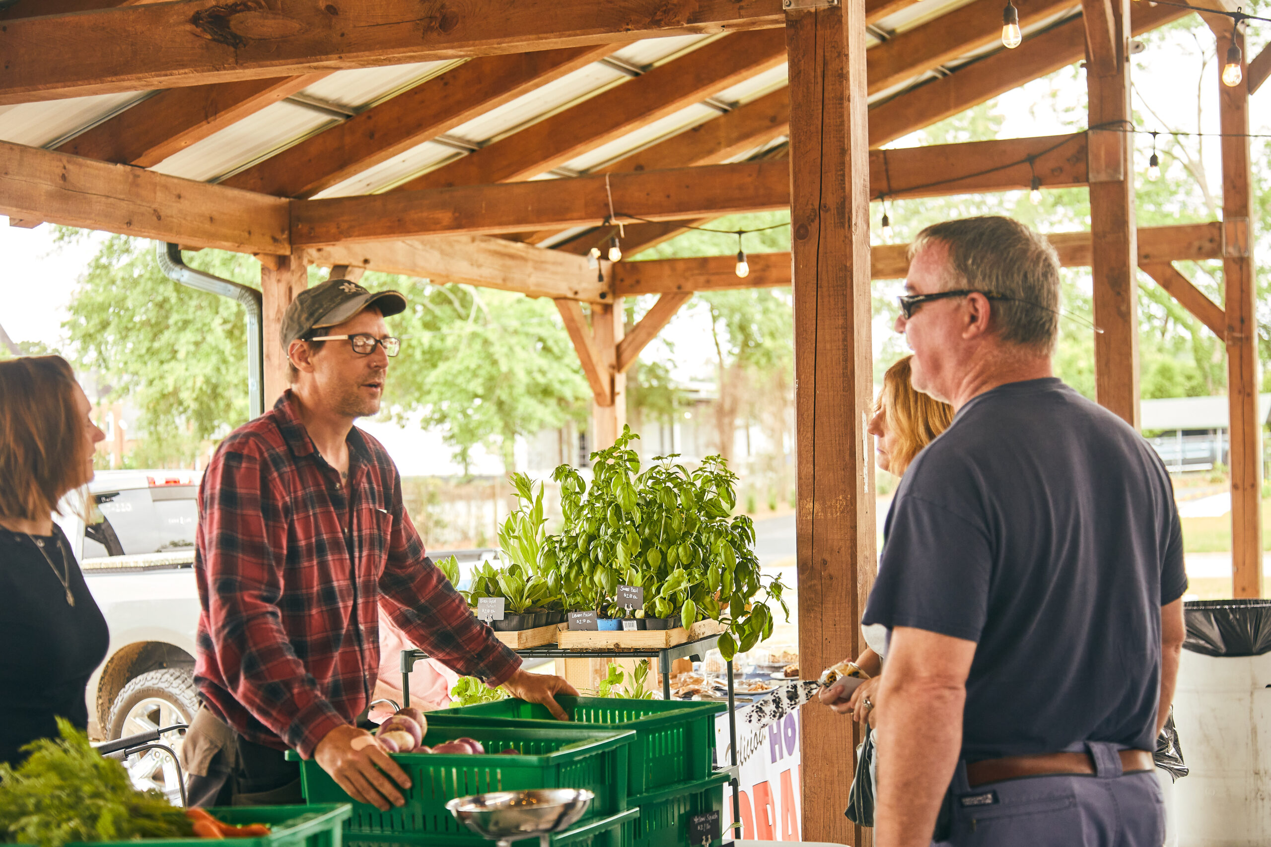 Vendor chatting with patron over a table of vegetables at Downtown Dublin's Farmers Market.