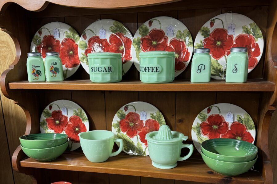 Jadeite glassware and floral dinner plates fill shelves at Emerald City Treasures