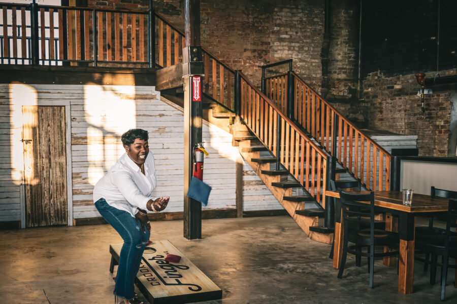 Woman plays cornhole at Crooked Finger Brewing to have more fun for her 2025 Resolution