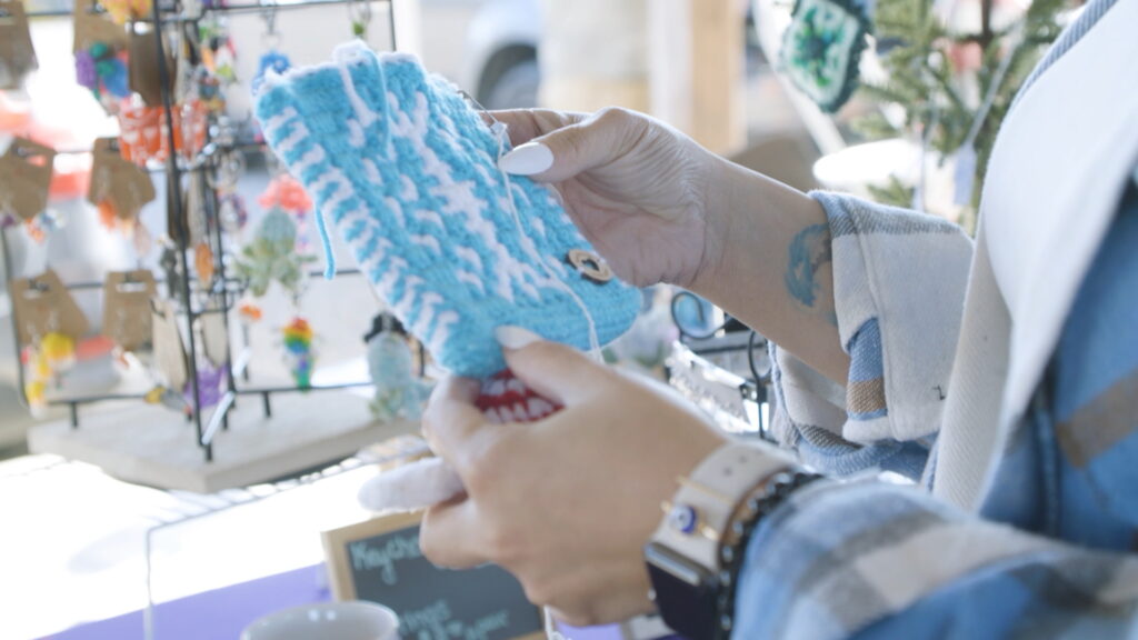 Customer holding a handmade pot holder being sold by a vendor at one of Dublin's many markets.