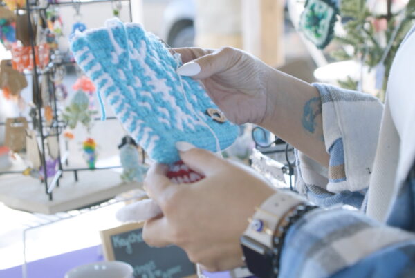 Customer holding a handmade pot holder being sold by a vendor at one of Dublin's many markets.