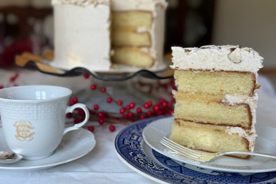 A slice of cake next to a coffee mug with the rest of the cake in the background as a teaser for the official 2026 Dublin Service League Fair & Marketplace cake