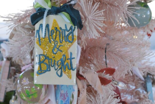 A hand painted ornament the says Merry & Bright to make a December to Remember