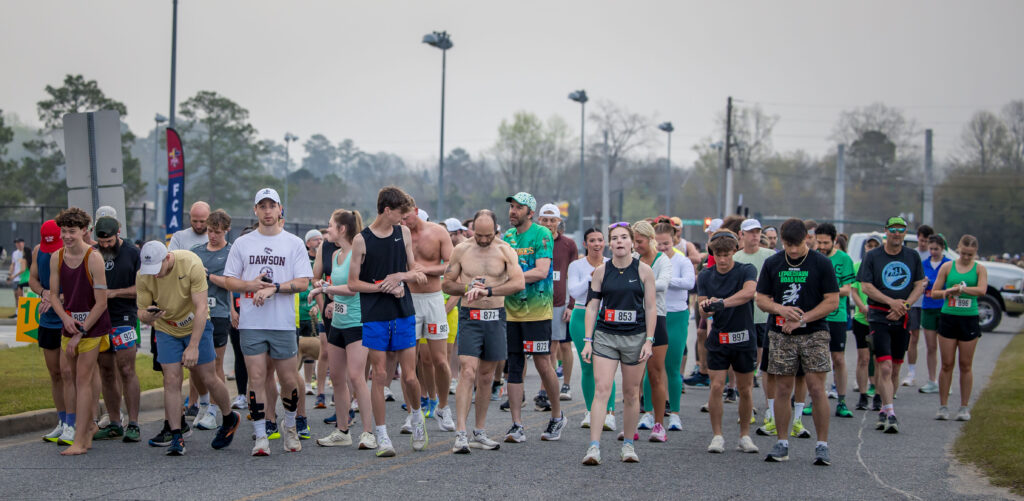 Huge group of runners in a crowd dotted in festive green, getting ready to take off at the start of the Leprechaun Road Race in Dublin, Georgia.