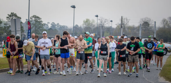 Huge group of runners in a crowd dotted in festive green, getting ready to take off at the start of the Leprechaun Road Race in Dublin, Georgia.