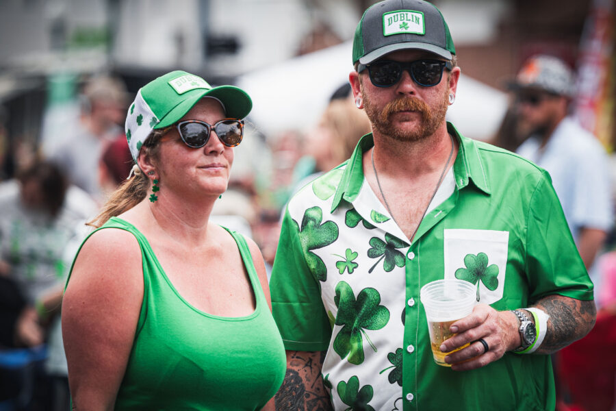Couple dressed in shamrocks enjoying a beer in the street of Downtown Dublin.