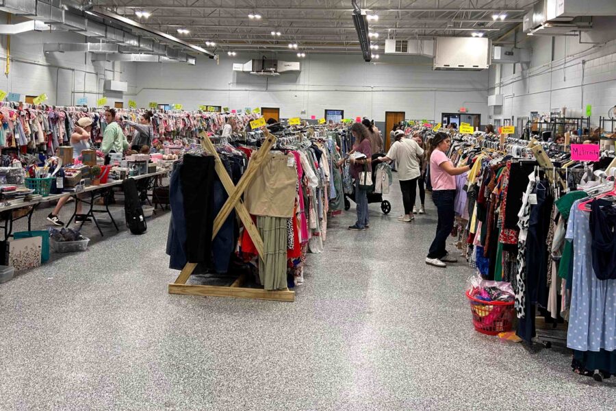People searching through racks and racks of clothing, used books, shoes, and more at the Emerald City Consignment Sale